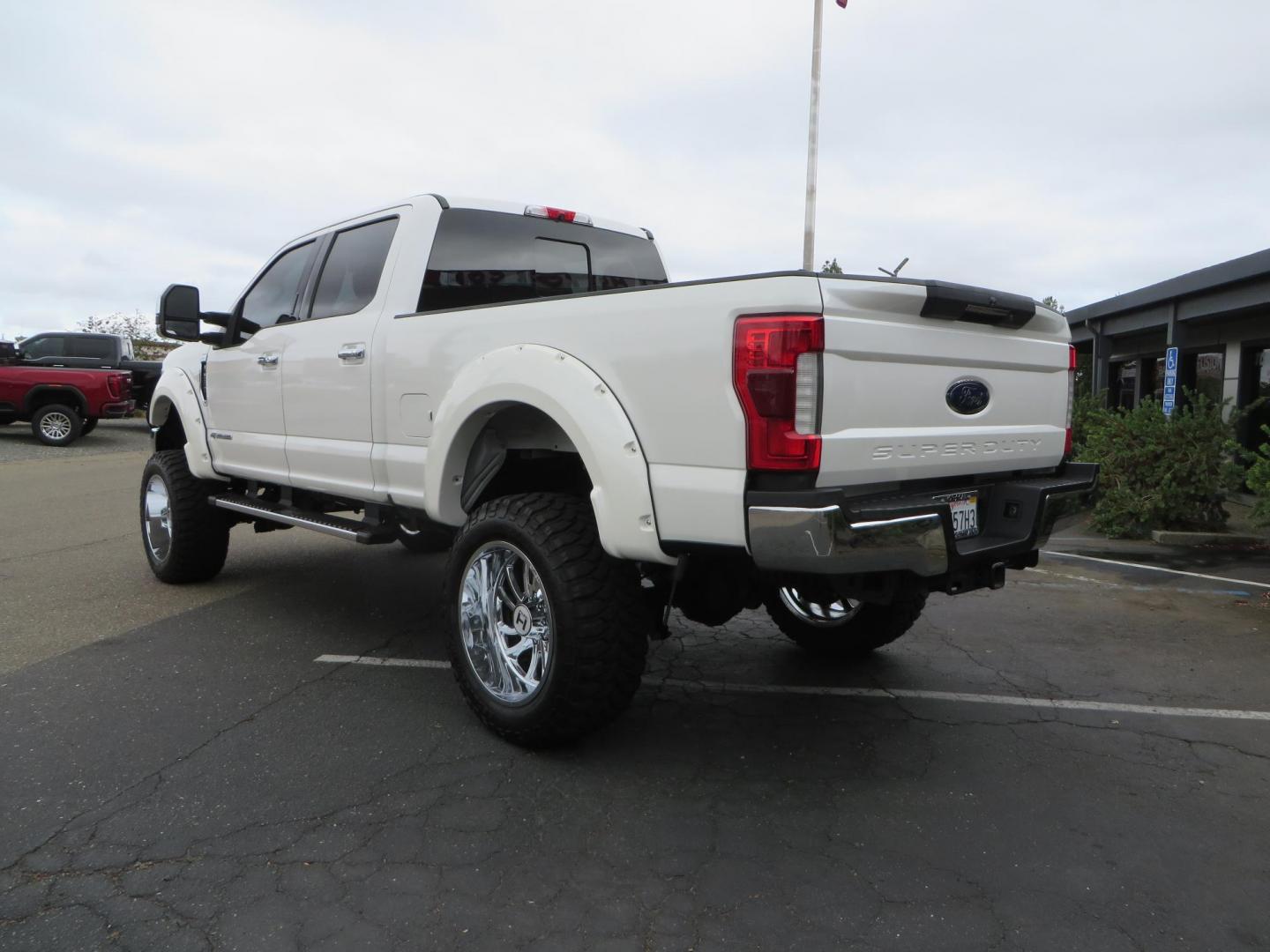 2019 White /Black Ford F-250 SD Lariat Crew Cab Short Bed 4WD (1FT7W2BT2KE) with an 6.7L V8 OHV 16V DIESEL engine, 6A transmission, located at 2630 Grass Valley Highway, Auburn, CA, 95603, (530) 508-5100, 38.937893, -121.095482 - Features a Fabtech 6" 4 link Lift kit, Fox remote reservoir shocks, 37" RBP MT tires, 22" Hostile wheels, Bushwacker Fender flares, Undercover Ultraflex bedcover, and window tint. - Photo#2