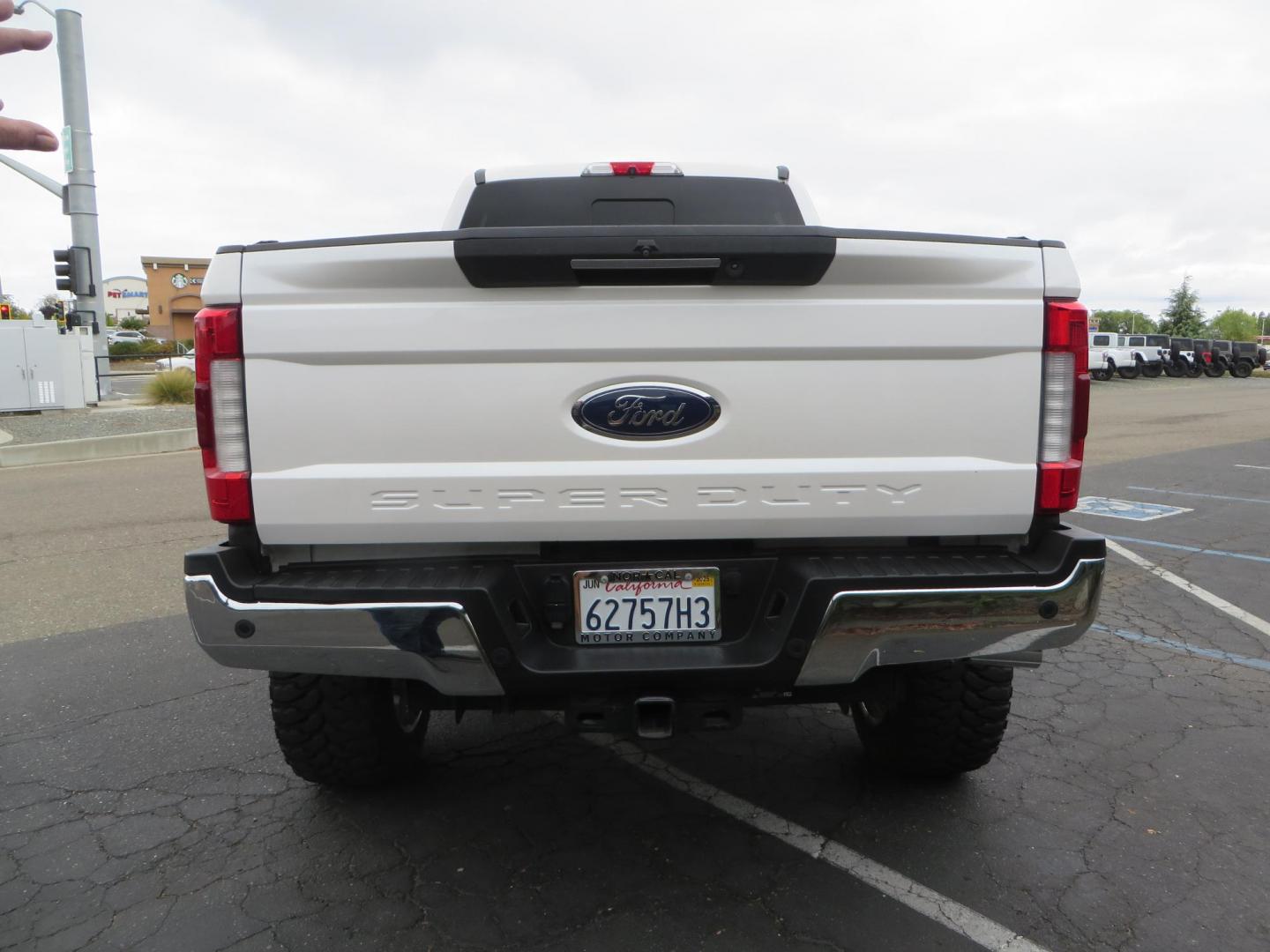 2019 White /Black Ford F-250 SD Lariat Crew Cab Short Bed 4WD (1FT7W2BT2KE) with an 6.7L V8 OHV 16V DIESEL engine, 6A transmission, located at 2630 Grass Valley Highway, Auburn, CA, 95603, (530) 508-5100, 38.937893, -121.095482 - Features a Fabtech 6" 4 link Lift kit, Fox remote reservoir shocks, 37" RBP MT tires, 22" Hostile wheels, Bushwacker Fender flares, Undercover Ultraflex bedcover, and window tint. - Photo#3
