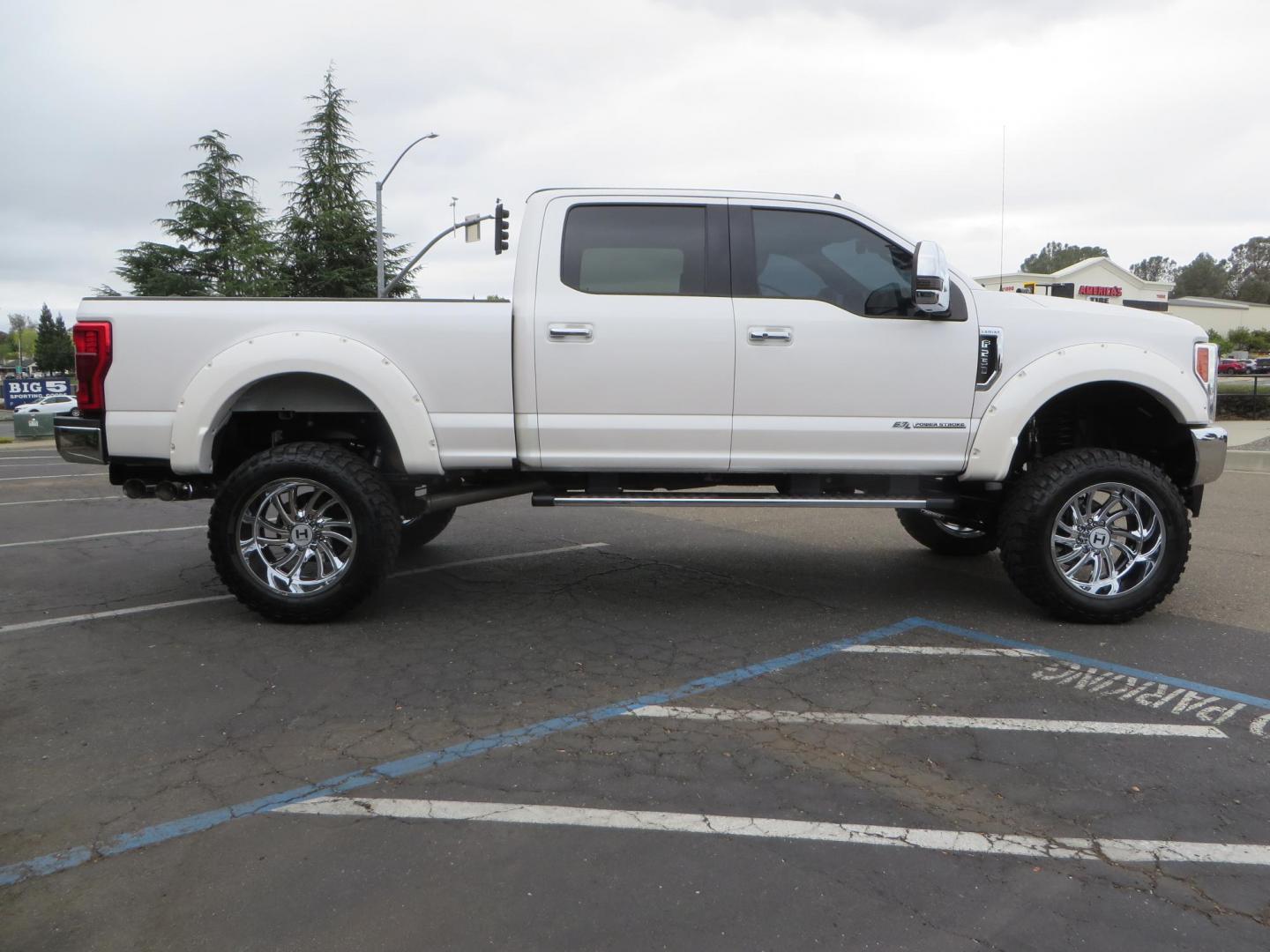 2019 White /Black Ford F-250 SD Lariat Crew Cab Short Bed 4WD (1FT7W2BT2KE) with an 6.7L V8 OHV 16V DIESEL engine, 6A transmission, located at 2630 Grass Valley Highway, Auburn, CA, 95603, (530) 508-5100, 38.937893, -121.095482 - Features a Fabtech 6" 4 link Lift kit, Fox remote reservoir shocks, 37" RBP MT tires, 22" Hostile wheels, Bushwacker Fender flares, Undercover Ultraflex bedcover, and window tint. - Photo#5