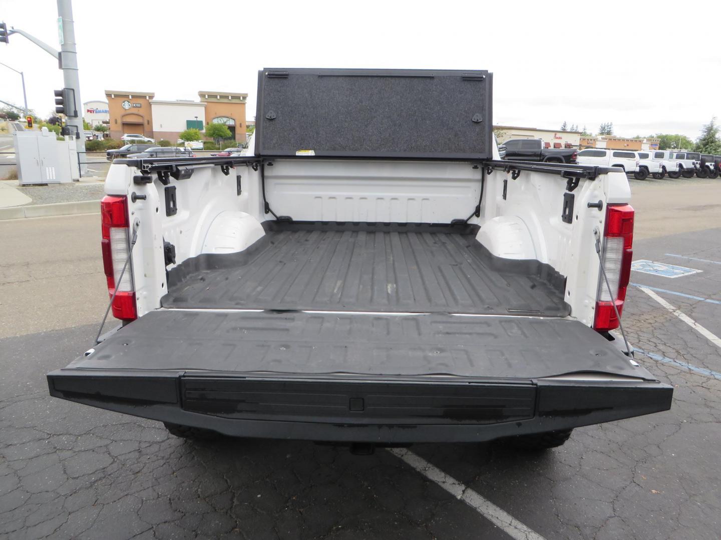 2019 White /Black Ford F-250 SD Lariat Crew Cab Short Bed 4WD (1FT7W2BT2KE) with an 6.7L V8 OHV 16V DIESEL engine, 6A transmission, located at 2630 Grass Valley Highway, Auburn, CA, 95603, (530) 508-5100, 38.937893, -121.095482 - Features a Fabtech 6" 4 link Lift kit, Fox remote reservoir shocks, 37" RBP MT tires, 22" Hostile wheels, Bushwacker Fender flares, Undercover Ultraflex bedcover, and window tint. - Photo#16